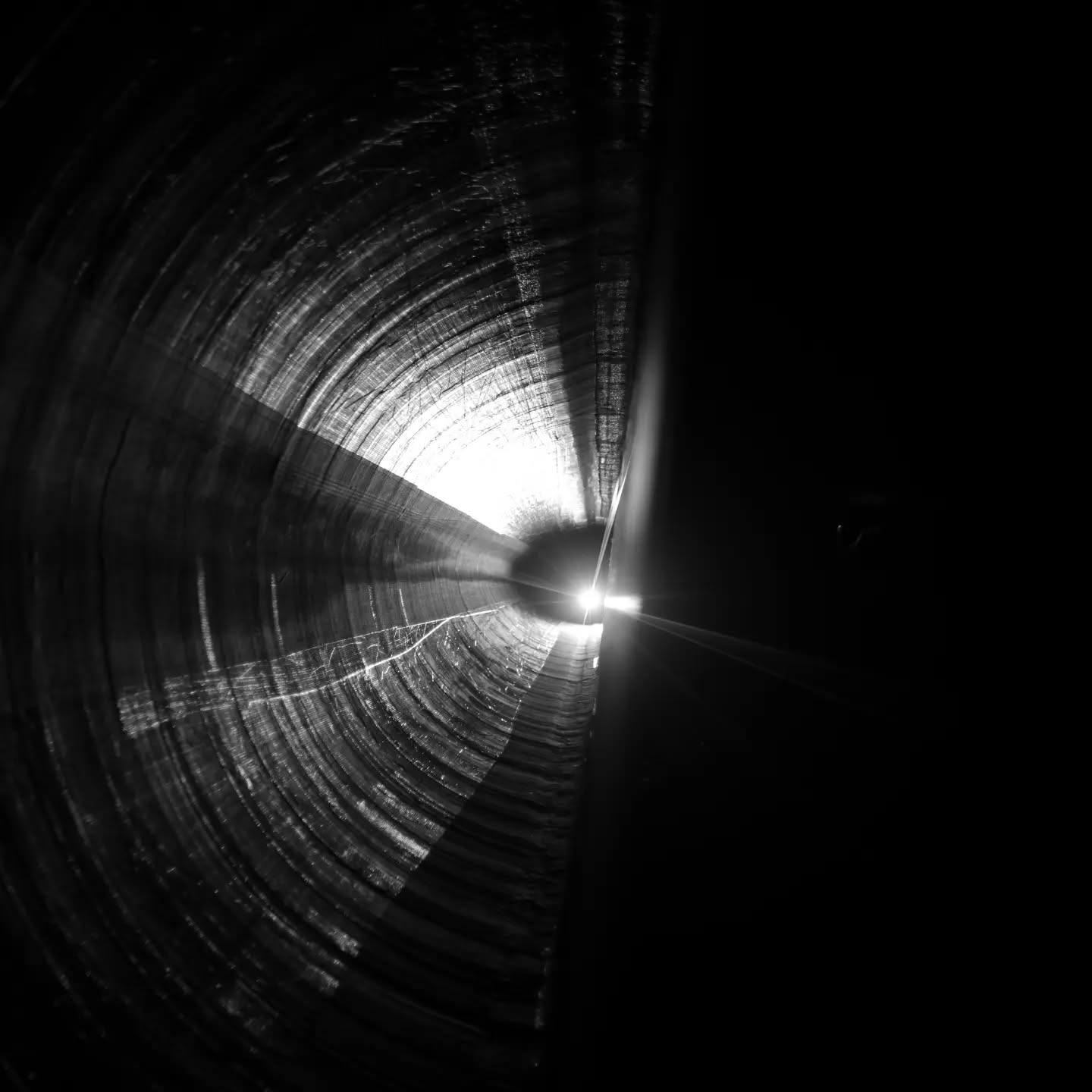 Black-and-white photograph related to wind energy conversion, featuring industrial equipment such as a turbine generator component.