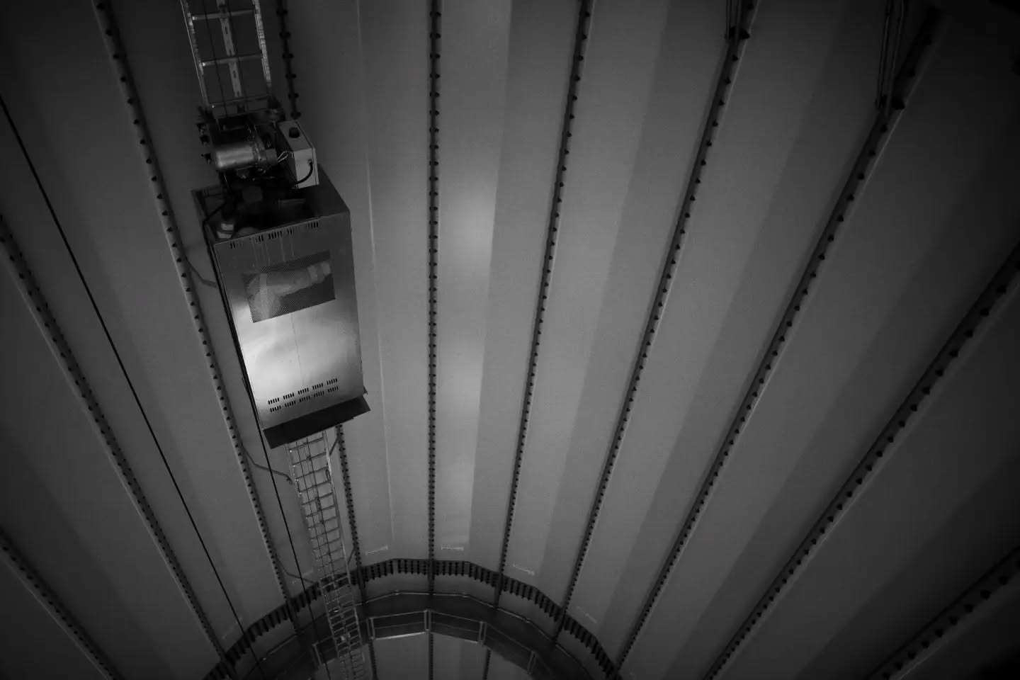Black and white photograph of a wind turbine, evoking a sense of motion and quiet grandeur.