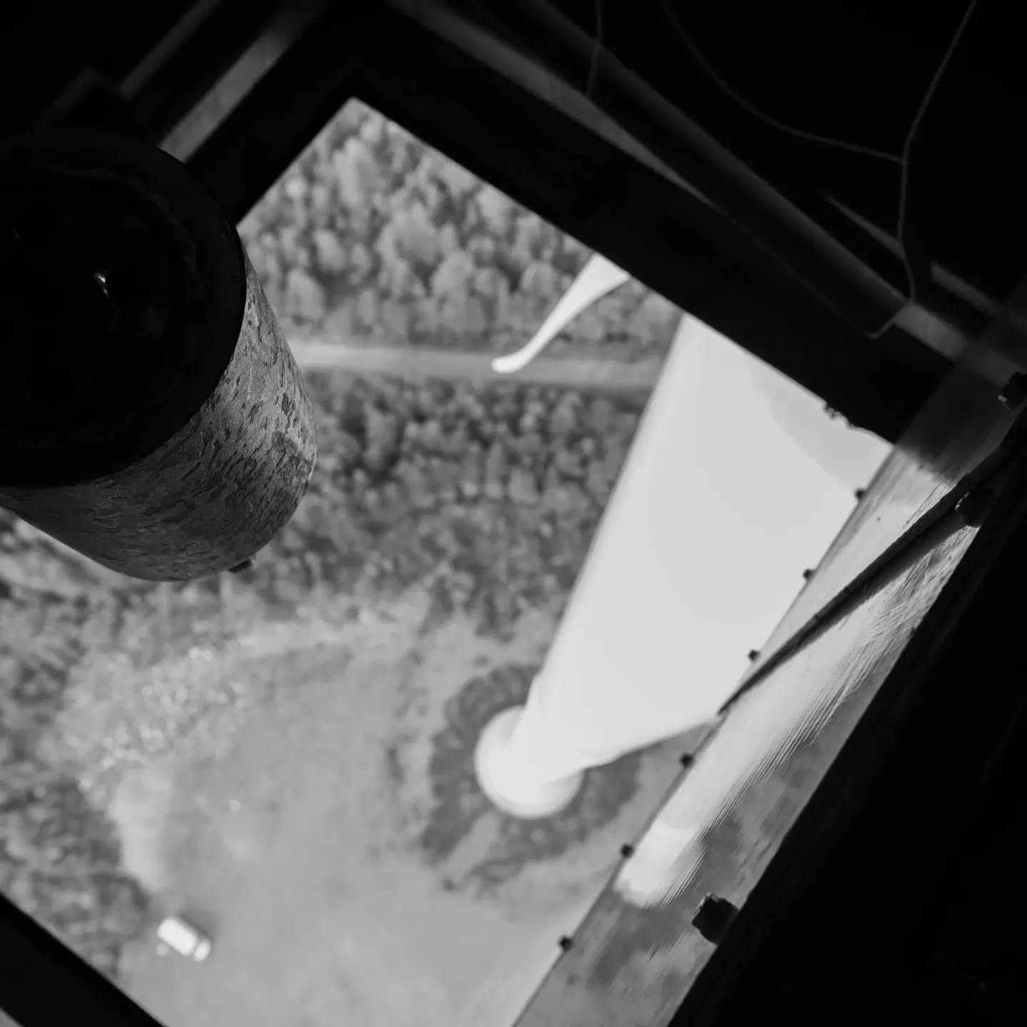 Black and white photograph of a wind turbine, framed as an environmentally symbolic image